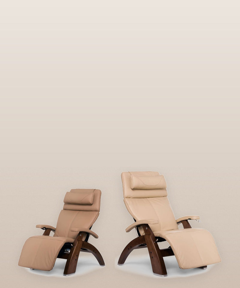 Two Human Touch Perfect Chair zero gravity recliners in tan leather with walnut wood bases